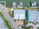 Aerial view of townhome with metal roof, brick driveway, private boat dock, and canal access at 100 Windrush Blvd # 1, Indian Rocks Beach, FL 33785