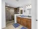 Bathroom features a modern glass enclosed shower and dual sink vanities with granite countertops at 100 Windrush Blvd # 1, Indian Rocks Beach, FL 33785