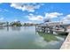 Waterfront property featuring a boat dock and lift with ample space for docking a boat, under a partly cloudy sky at 100 Windrush Blvd # 1, Indian Rocks Beach, FL 33785