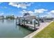 View of a boat dock featuring a boat lift with a white boat, providing convenient access to the water for boating at 100 Windrush Blvd # 1, Indian Rocks Beach, FL 33785