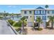 Beautiful two-story townhomes in yellow and blue with private garages and brick paver driveways near the water at 100 Windrush Blvd # 1, Indian Rocks Beach, FL 33785