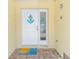 Charming front door with nautical decor, a cute welcome mat, and a yellow exterior wall creating a warm entryway at 100 Windrush Blvd # 1, Indian Rocks Beach, FL 33785