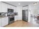 Well-equipped kitchen features stainless steel appliances, tiled backsplash, and wood-look floors at 100 Windrush Blvd # 1, Indian Rocks Beach, FL 33785