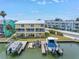 Waterfront townhome featuring multiple balconies, a boat dock, and scenic water views perfect for coastal living at 100 Windrush Blvd # 1, Indian Rocks Beach, FL 33785