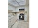 Kitchen featuring white cabinets and appliances, stainless steel oven, and tile floors at 1001 77Th N Ave # 206, St Petersburg, FL 33702
