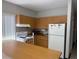 A cozy kitchen boasts wood cabinets, a modern white range, and a full-size refrigerator for your culinary needs at 1001 77Th N Ave # 206, St Petersburg, FL 33702