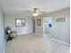 Open-concept living room with tile floors, neutral paint, ceiling fan, and a peek into the kitchen at 1001 77Th N Ave # 206, St Petersburg, FL 33702