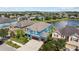 Aerial view of blue home with brown roof near pond showing community setting at 10017 Smarty Jones Dr, Ruskin, FL 33573