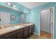 Well-lit bathroom featuring a double sink vanity and blue wall paint at 10017 Smarty Jones Dr, Ruskin, FL 33573