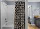 Bathroom featuring a bathtub with shower and black patterned shower curtain at 10017 Smarty Jones Dr, Ruskin, FL 33573