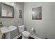 Charming powder room featuring pedestal sink, framed mirror, and tasteful Parisian decor at 10017 Smarty Jones Dr, Ruskin, FL 33573