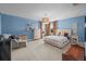Spacious bedroom with blue walls and a plush bed complemented by orange drapes, inviting natural light at 10017 Smarty Jones Dr, Ruskin, FL 33573