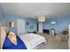 Charming bedroom featuring blue walls, a queen size bed, TV, and accent chair at 10017 Smarty Jones Dr, Ruskin, FL 33573