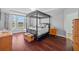 Serene bedroom with a four-poster bed, water views, and hardwood floors at 10017 Smarty Jones Dr, Ruskin, FL 33573
