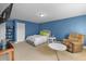 This bedroom features blue walls, a cozy chair, and a comfortable bed at 10017 Smarty Jones Dr, Ruskin, FL 33573
