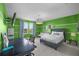 Comfortable bedroom featuring colorful green walls, desk, TV, and lots of natural light at 10017 Smarty Jones Dr, Ruskin, FL 33573