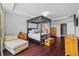 This bedroom features a four poster bed, wood floors, and en suite bath at 10017 Smarty Jones Dr, Ruskin, FL 33573
