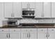 Close-up of kitchen featuring modern appliances, mosaic backsplash, granite countertops, and white cabinets at 10017 Smarty Jones Dr, Ruskin, FL 33573