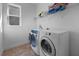 Functional laundry room featuring a washer, dryer, window, and storage shelf at 10017 Smarty Jones Dr, Ruskin, FL 33573
