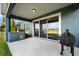 Covered patio with grill and sliding glass door to the backyard with lake view at 10017 Smarty Jones Dr, Ruskin, FL 33573