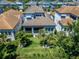 A bird's eye view reveals a manicured lawn, tropical trees, and a covered porch at 1025 Seagrape Dr, Ruskin, FL 33570