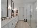 Modern bathroom with double vanity, marble countertops, large mirrors, and a glass-enclosed shower with a built-in bench at 1025 Seagrape Dr, Ruskin, FL 33570