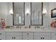 Stylish bathroom boasting double vanities with marble counters, modern lighting, and a glass-enclosed shower, blending functionality with design at 1025 Seagrape Dr, Ruskin, FL 33570