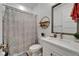 Bathroom with vanity, decorative shower curtain, floating shelves with decor at 1025 Seagrape Dr, Ruskin, FL 33570