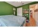 Green bedroom with a bed, sliding door closet, and bohemian decor at 1025 Seagrape Dr, Ruskin, FL 33570