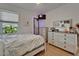 Well-lit bedroom with hardwood floors, dressers, and a large window with natural light at 1025 Seagrape Dr, Ruskin, FL 33570