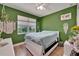 Bedroom features vibrant green walls, boho decor, and natural light at 1025 Seagrape Dr, Ruskin, FL 33570