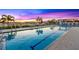 Pool with lap lanes reflecting a colorful sky and surrounded by lounge chairs and greenery at 1025 Seagrape Dr, Ruskin, FL 33570