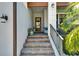 Inviting entryway with brick steps, decorative plants, and a stylish glass front door at 1025 Seagrape Dr, Ruskin, FL 33570