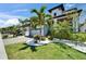 Beautiful two-story home featuring palm trees, manicured landscaping, and a brick driveway at 1025 Seagrape Dr, Ruskin, FL 33570