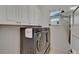 The laundry room boasts modern washer and dryer set, plus storage cabinets at 1025 Seagrape Dr, Ruskin, FL 33570