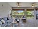 Inviting screened patio features comfortable seating, ceiling fans, and serene outdoor views at 1025 Seagrape Dr, Ruskin, FL 33570