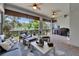 Covered patio with ceiling fans, outdoor seating, and a grill, overlooking lush greenery, perfect for outdoor entertaining at 1025 Seagrape Dr, Ruskin, FL 33570
