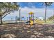 Community playground featuring a yellow slide, climbing area, and a backdrop of water views at 1025 Seagrape Dr, Ruskin, FL 33570