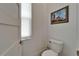 This powder room features a modern toilet and elegant lighthouse artwork on the wall at 1025 Seagrape Dr, Ruskin, FL 33570