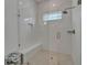 Luxurious glass-enclosed shower with built-in bench, rainfall showerhead, and white tiled walls, creating a spa-like experience at 1025 Seagrape Dr, Ruskin, FL 33570