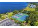 Overhead view of a bayside tennis court featuring four courts, lush landscaping, and water views at 1025 Seagrape Dr, Ruskin, FL 33570