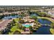 An aerial view of a community pool, lounge and landscaping, situated near a tranquil lake at 10265 Gandy N Blvd # 1406, St Petersburg, FL 33702