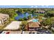 Aerial view showcasing a community pool, clubhouse, volleyball court, and serene lake at 10265 Gandy N Blvd # 1406, St Petersburg, FL 33702