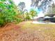 Spacious backyard featuring lush landscaping and a screened-in pool area with patio furniture at 11272 Portsmouth St, Spring Hill, FL 34609