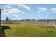 A large backyard features a manicured lawn, a white fence, and views of the tranquil lake at 11938 Bahia Valley Dr, Riverview, FL 33579