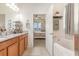 Bright bathroom featuring a soaking tub, dual sink vanity with granite countertop and bedroom access at 11938 Bahia Valley Dr, Riverview, FL 33579