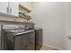 Functional laundry room with modern washer and dryer, upper and lower cabinets, and tiled floor at 11938 Bahia Valley Dr, Riverview, FL 33579