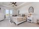 Bright main bedroom with a ceiling fan, tray ceiling, soft carpet, and a view of the outdoors at 11938 Bahia Valley Dr, Riverview, FL 33579
