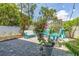 Backyard area with brick pavers, string lights, a bench, chairs, and privacy fence at 1237 Savona Ne Dr, St Petersburg, FL 33702