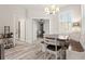 Bright dining area with a modern chandelier, bench seating, and beautiful wood-look floors at 1237 Savona Ne Dr, St Petersburg, FL 33702